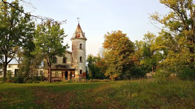 Small old house with a round tower in the Latvian village of Jaungulbene on October 2, 2020.