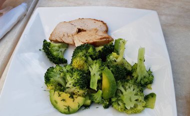 Beyaz tabakta haşlanmış domuz eti ve lahana salatası..