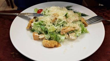 Taze sebze salatası, kızarmış ekmek ve tabakta tavuk parçaları..