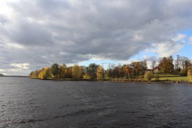 Nehrin karşı kıyısındaki panorama. Sarı sonbahar ağaçları var..