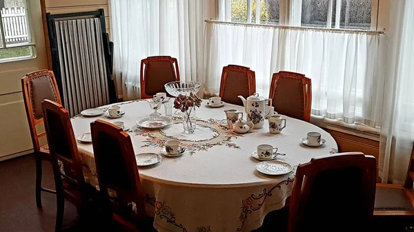 13 Kasım 2020 'de Letonya' nın Jurmala kentindeki Aspazija evinde büyük bir oval masada çay takımı hazırlanır. — Stok fotoğraf
