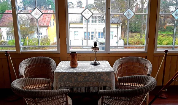 Sul tavolo c'è una lampada al cherosene e quattro sedie di vimini nella casa Aspazija nella città lettone di Jurmala il 13 novembre 2020 — Foto Stock