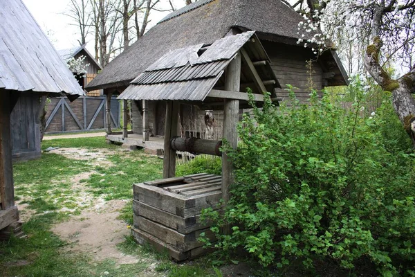 Alter Brunnen zwischen Holzhäusern in der lettischen Cinevilla am 17. Mai 2019 — Stockfoto