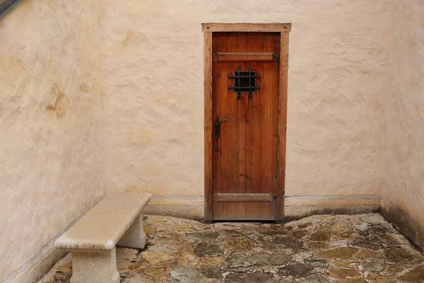 Köy çiftliğindeki bir ahırın taş duvarındaki ahşap kapı..