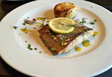 Bir dilim limon ve patates püresiyle buğulanmış balık..