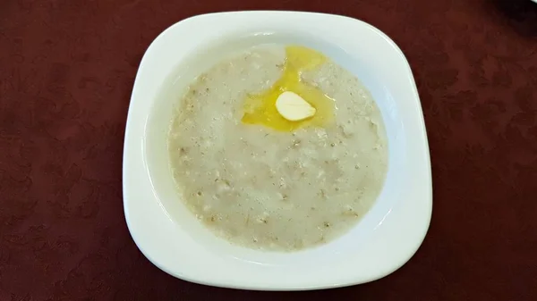 朝食のために用意された白いプレートにおいしく健康的なオートミールのお粥 — ストック写真