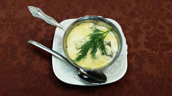Tavuk ve mantarlı jülyen, öğle yemeği için pişirilmiş küçük bir metal kasede..