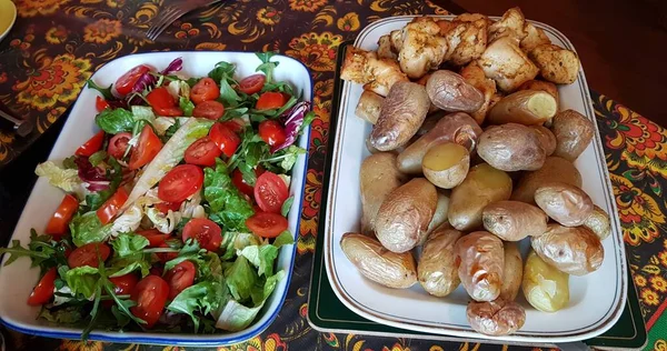 Dilimlenmiş tavuk ve fırında pişmiş taze patates ve yeşil salatalı taze domates salatası..