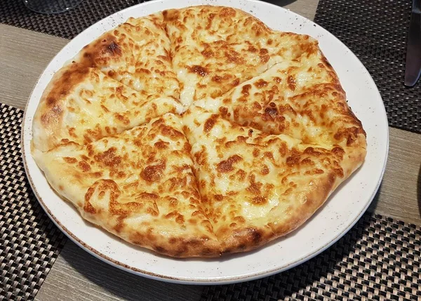 Akşam yemeği için hazırlanmış büyük tabakta peynirli lezzetli pita ekmeği..