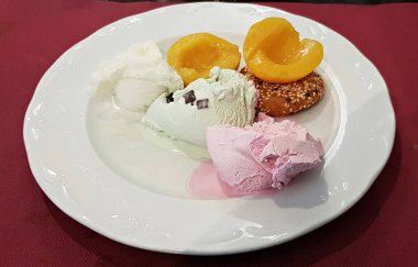 Dondurma çeşitleri tatlı küçük kek ve beyaz tabakta konserve şeftali..