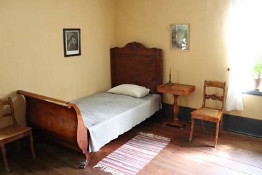 Sigulda 'daki Turaida Kalesi' nin müdürünün kulübesinde tek kişilik ahşap bir yatak. Letonya, Temmuz 2019.