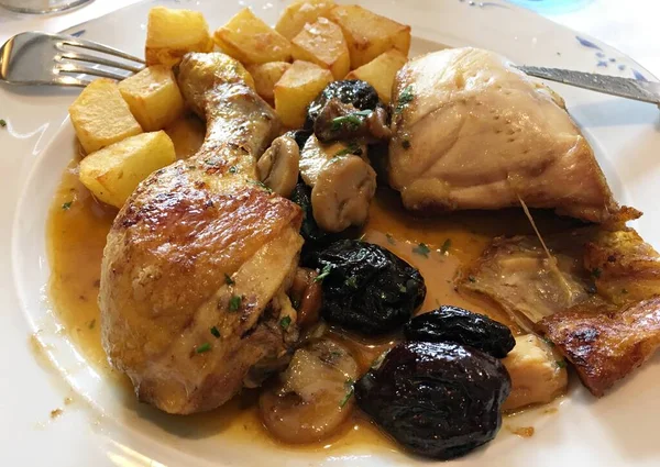 Lezzetli haşlanmış tavuk budu ve haşlanmış patates dilimleri beyaz bir tabakta..