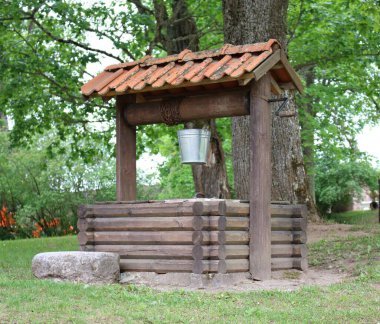 Kova, köy avlusundaki ahşap bir kuyunun etrafındaki zincir yarasına sabitlenmiş..