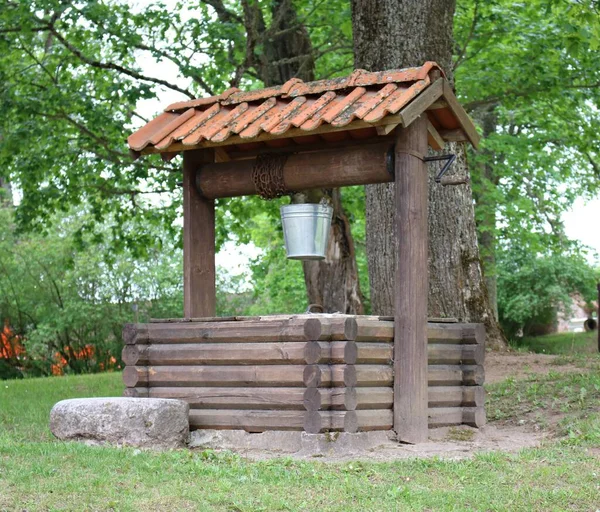 Kova, köy avlusundaki ahşap bir kuyunun etrafındaki zincir yarasına sabitlenmiş..