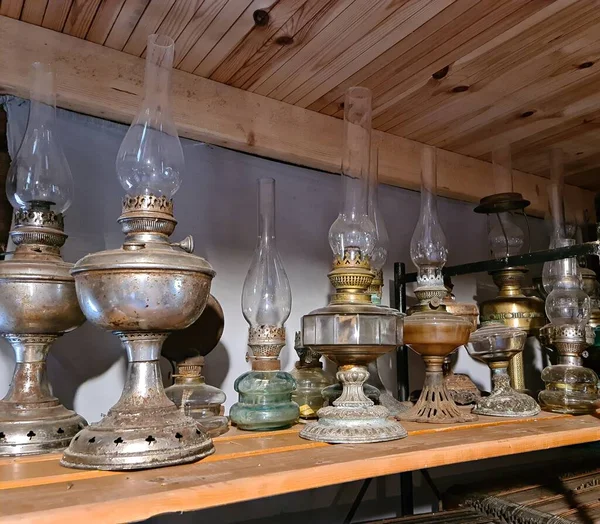 Ahşap bir raftaki eski masa lambaları bir zamanlar evleri aydınlatmak için kullanılırdı..