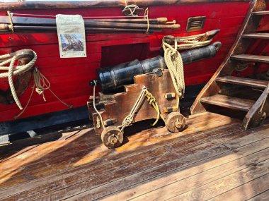 Eski bir geminin topları ahşap yelkenli güvertesinde iplerle sabitlenir..