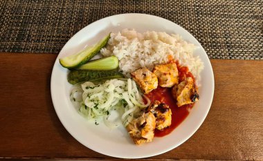 Kızarmış tavuk eti ve haşlanmış pirinç öğle yemeği için pişirilir..