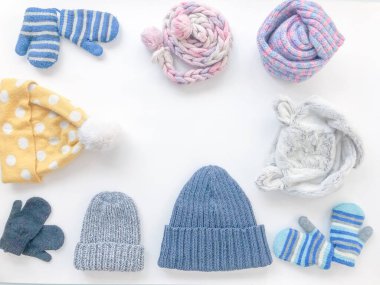 Beyaz arka planda kış aksesuarları, şapkalar, eşarplar, eldivenler