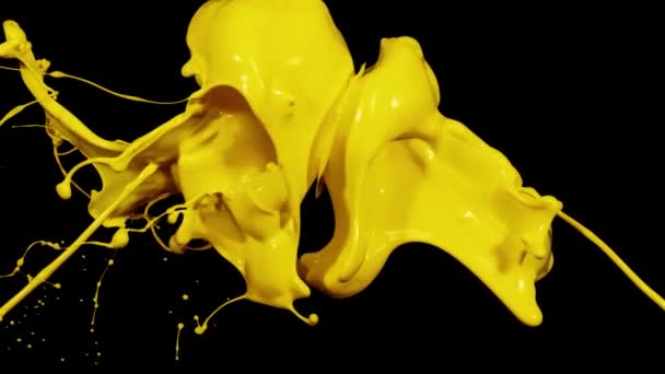 Splashes of yellow paint in macro photography — стоковое видео