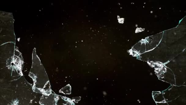 Fragments of broken glass fly in different directions on a black background. — Video Stock