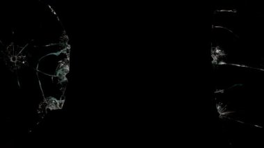 Kırık cam parçaları siyah arka planda farklı yönlere uçuyor..