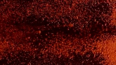 Siyah arkaplanda renkli toz, yavaş çekimde tepeden tırnağa yerel olarak düşüyor.