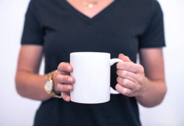 Kadınların elinde beyaz bir kupa. Beyaz bir arkaplanda