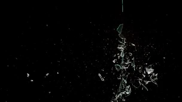 Fragments of broken glass fly in different directions on a black background. — 图库视频影像