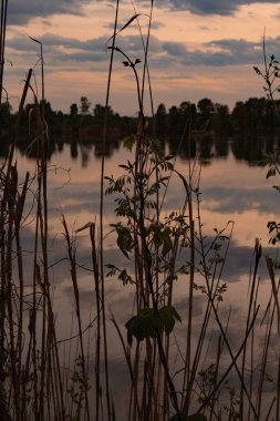 Nehir bulutları üzerindeki sihirli gün batımı suya yansıyor.