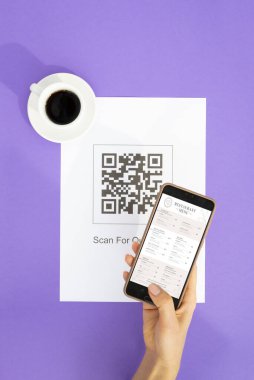 Top view Hand 'in müşteri taraması QR kodlu online menü servisi için restorandaki masada. Restaurantta yeni teknolojisiz yaşam tarzı koruma koronavirüsü salgını. Düz yatıyordu
