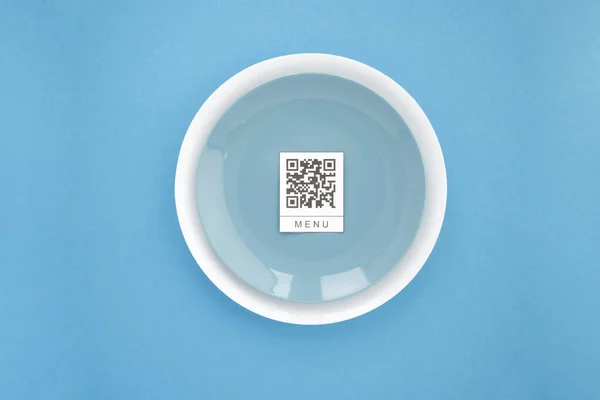 Restorandaki masada online menü servisi için QR kodu. Restaurantta yeni teknolojisiz yaşam tarzı koruma koronavirüsü salgını. Düz, mavi arkaplan