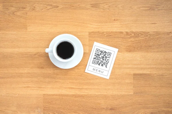 Restorandaki masada online menü servisi için QR kodu. Restaurantta yeni teknolojisiz yaşam tarzı koruma koronavirüsü salgını. Düz, ahşap masa.