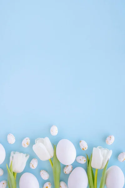 Yumurta, lale ve mavi arkaplanlı mutlu paskalya arkaplanları. Düz yatış, üst görünüm