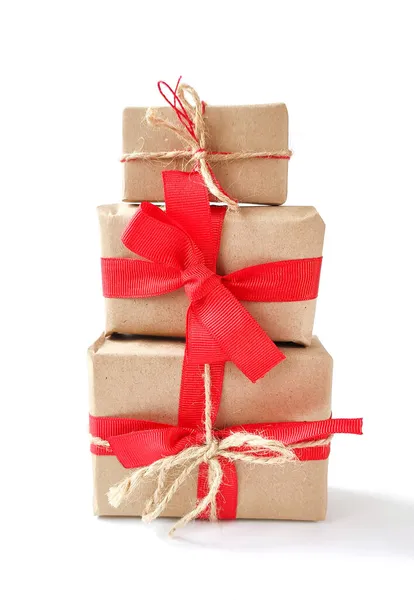 Beyaz üzerine kırmızı kurdele yayı ayrılmış el sanatları kağıdına sarılmış antika hediye kutuları. Noel hediyeleri.