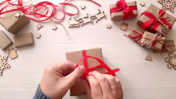 Mãos Homem Embrulham Natal Presente Papel Artesanal Com Fita Vermelha — Vídeo de Stock
