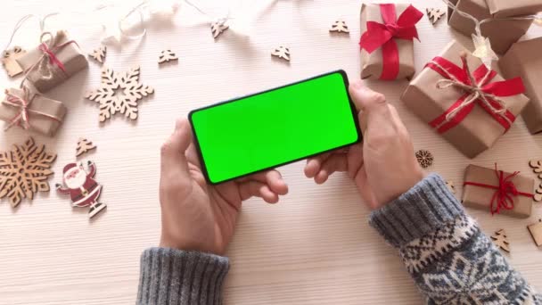 Чоловік Тримає Смартфон Вертикальним Зеленим Екраном Різдвяному Фоні Подарунками Мобільний — стокове відео