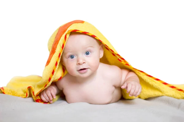 Little baby boy smiling under yellow towel. — Stock Photo, Image