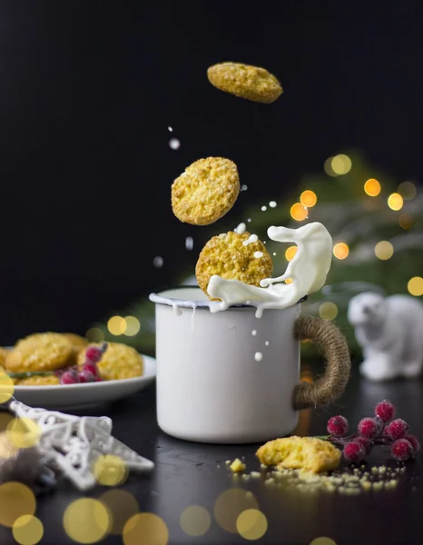 Kekse fallen und spritzen in einen Becher Milch. — Stockfoto