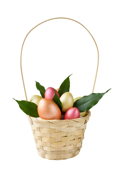 Golden, bronze and pink Easter eggs with green leaves in basket isolated on white background. Design element for greeting cards, poster or banner.