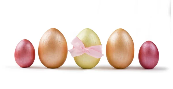 Cute golden and pink metallic Easter eggs with bow in a row isolated on white background. Design element for greeting cards, poster or banner.