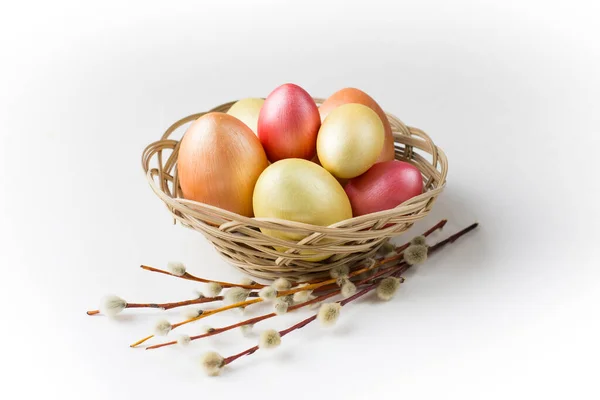 Golden, bronze and pink Easter eggs with pussy willow in basket. Design element for greeting cards, poster or banner.
