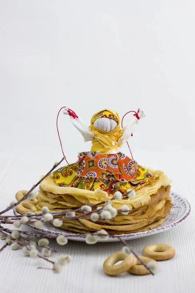Background with pancakes, textile doll, sushki and pussy-willow on white for Maslenitsa festival. Traditional Russian meal for Shrovetide. Greeting card or poster. Copy space.