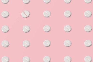 Beyaz tabletlerden, haplardan ve tek bir kırık haptan oluşan modaya uygun pembe desenler. Pembe arka plan. Asgari ve geometrik kavram.