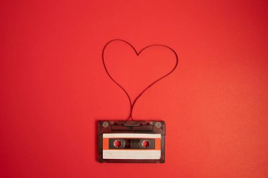 Ses kaseti. Kızıl Arkaplan. Müzik konsepti. Teyp. Kalp banttan yapılmış. Aşk fikri..