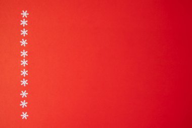 Kırmızı arkaplanda kar tanelerinden oluşan çizgi.