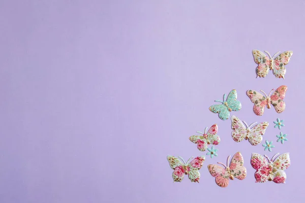 紫色背景的彩色塑料蝴蝶 图库图片