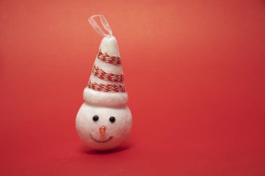 Şapkalı güzel bir kardan adam kafası. Kırmızı arka plan. Yeni yıl ve Noel fikri. tatiller