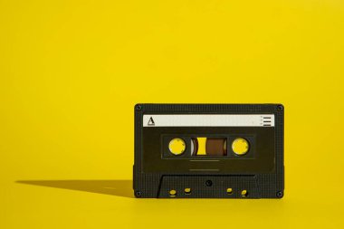 Siyah ses kaseti, sarı arka planda bant. Havalı müzikal ve retro fikir