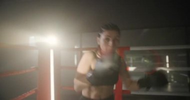 Kadın Trenlerinin Yumruklarını Kapat Kameraya Doğrudan Bakıyor. Güçlü Saldırgan Genç Kadın Feminizm ve Başarılı Kadın Sembolü olarak Ringde Boks Yapıyor