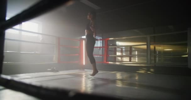 Młoda kobieta bokser Z jej ręce zawinięte w bandaż skakanie na linie w ciemnym pierścieniu przestrzeń siłownia z dymem. — Wideo stockowe